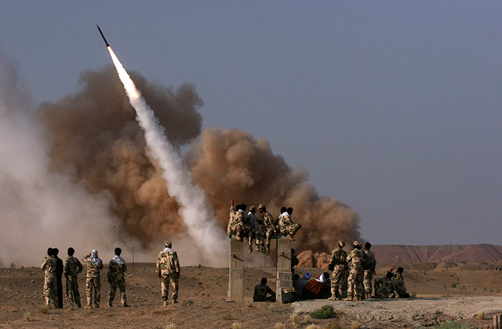 24 hours in pictures: Iranian revolutionary Guards personnel watch the launch of a Zelzal missile