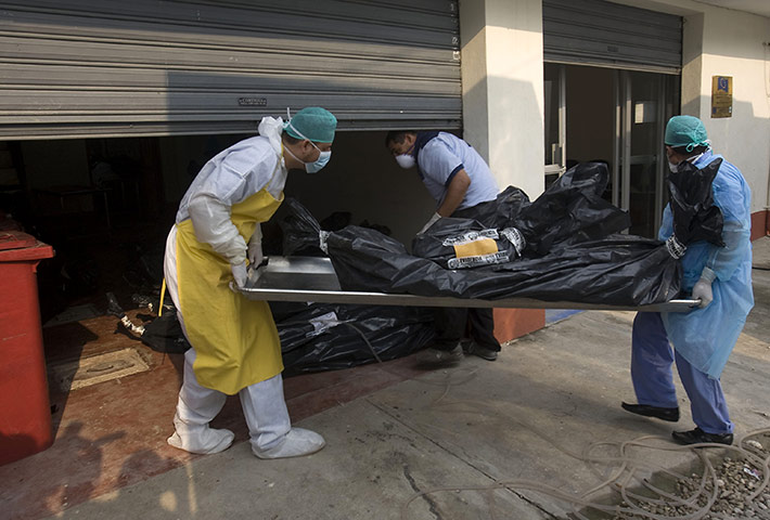 Guatemala gang wars: Morgue employees carry a body