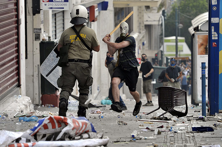 Greece strikes : A protestor charges at police