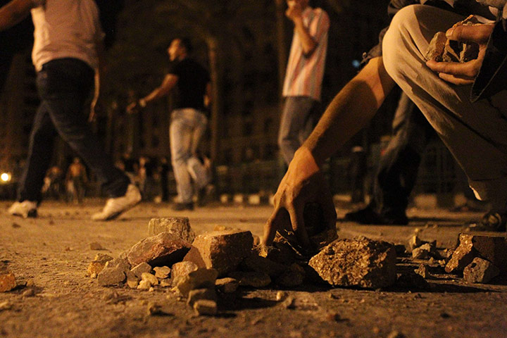 Cairo Clashes: An Egyptian protester collects stones