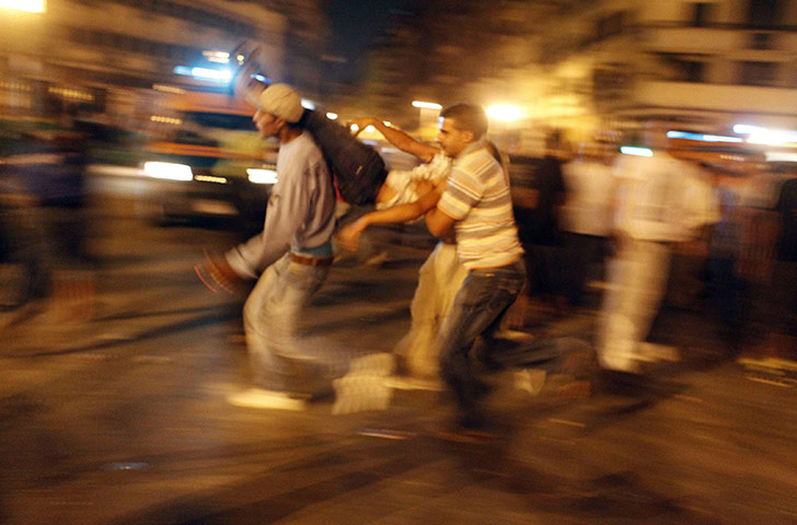 Cairo Clashes: Protesters carry an injured man in Tahrir Square