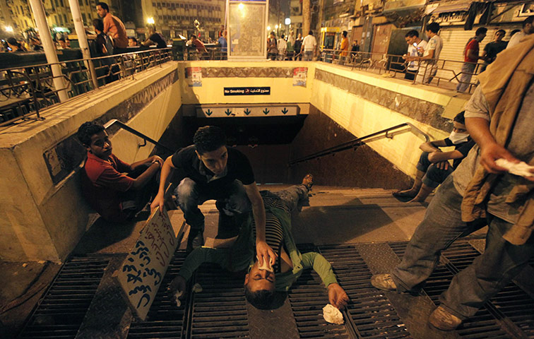Cairo Clashes: An Egyptian protester helps an injured fellow protester