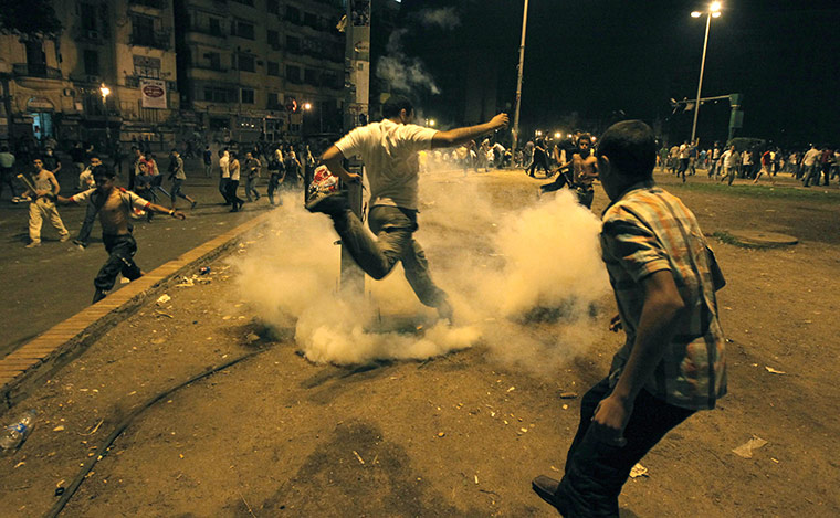 Cairo Clashes: A protester kicks a tear gas canister