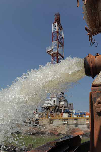 Southern Sudan: Water is poured into a pond near oil drilling site