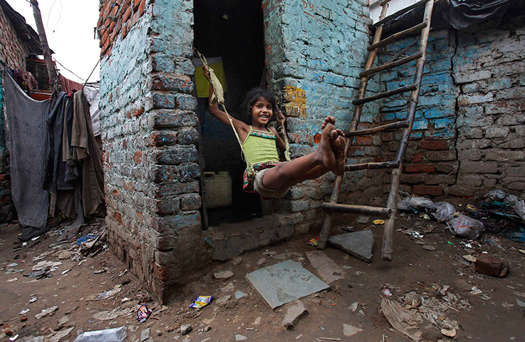 24 hours in pictures: A girl plays on a make-shift swing tied on a door frame in New Delhi