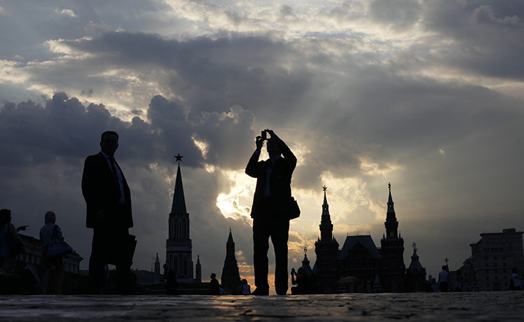 24 hours in pictures: People walk under stormy skies as the sun sets at the Red Square