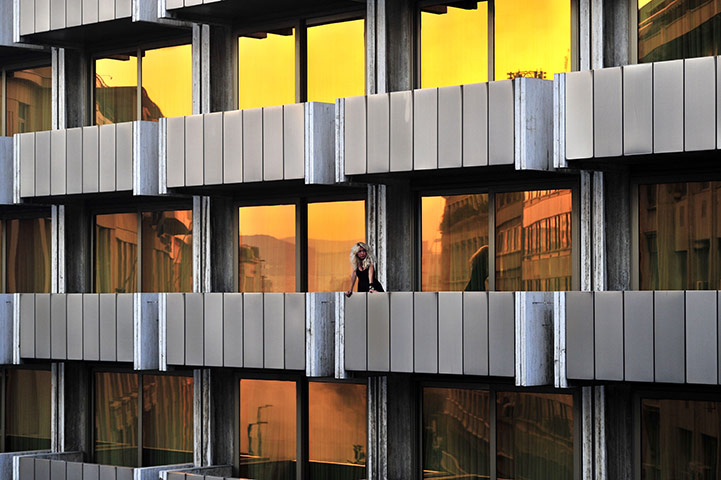 24 hours in pictures: A woman watches between protesters and riot police in Athens