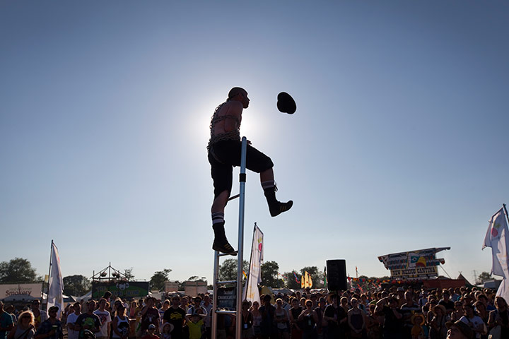 Glastonbury: A performer bound in chains up a ladder, Glastonbury festival