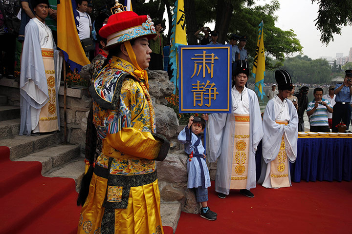 24 hours: Beijing, China: A child takes picture of a man dressed as a Chinese emperor