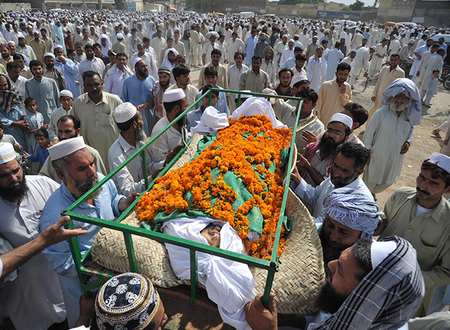 24 hours: Peshawar, Pakistan: Mourners carry the coffin of a blast victim