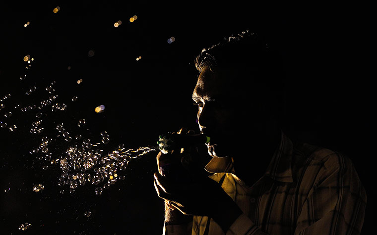 24 hours in pictures: A street side vendor blows bubbles, India