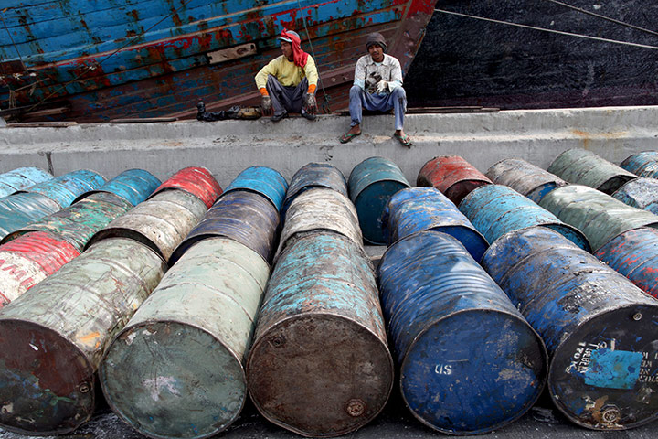 24 hours in pictures: Two Indonesian workers guard hundreds of drums full of palm oil waste