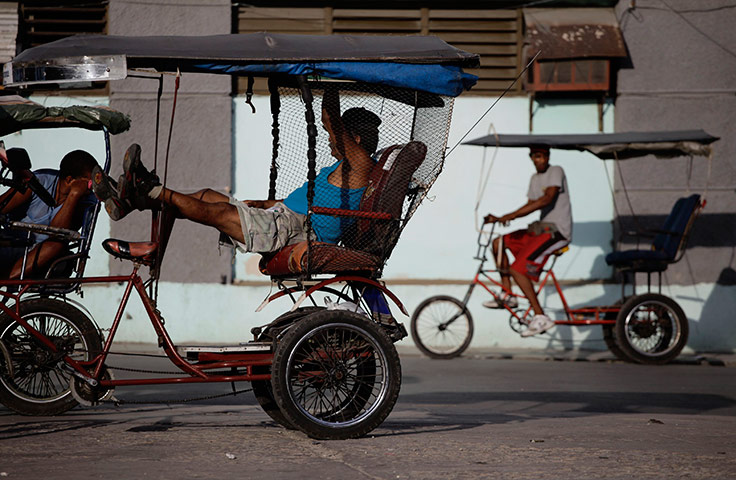 24 hours in pictures: Men wait for customers on their tricycle taxis in Havana