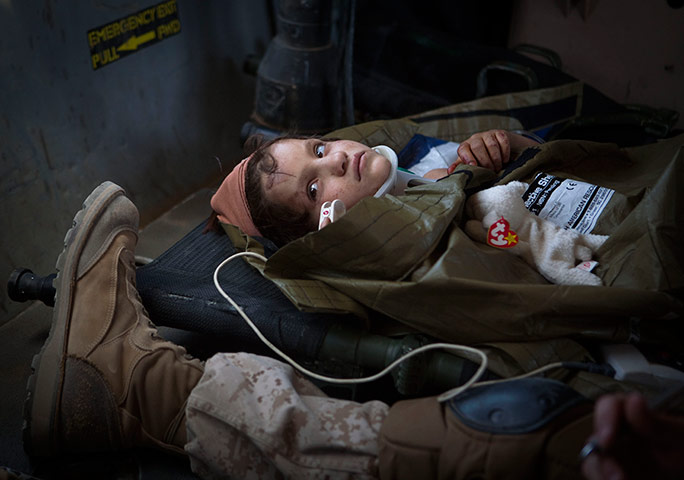 24 hours in pics: Afghan girl looks up as she flies onboard a Medevac helicopter
