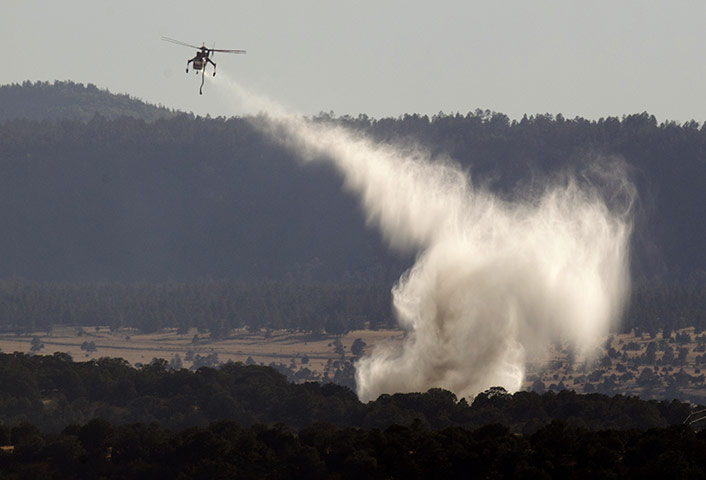 Arizona Wildfires: A sky crane makes a water drop on a spot fire
