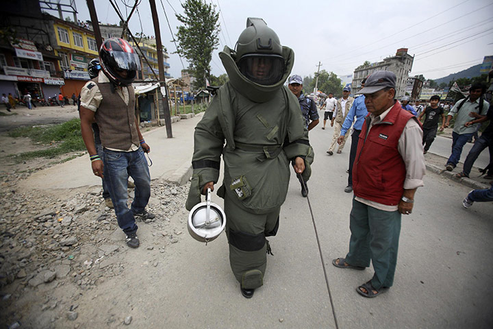 24 hours: Kathmandu, Nepal: A member of a bomb disposal team holds a pressure cooker 