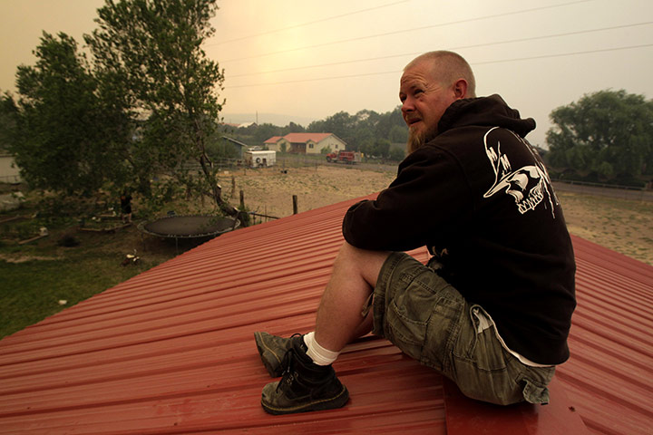 Arizona Wildfires: Lucas Malone sits on a rooftop