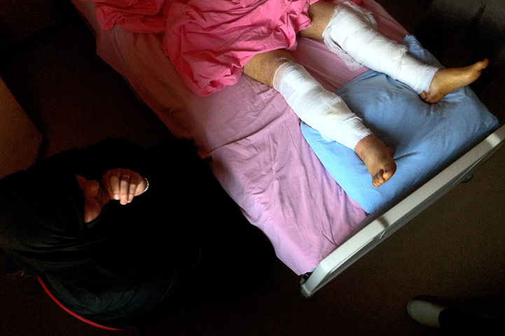 Syrian Refugees: A Syrian woman waits beside her wounded husband 