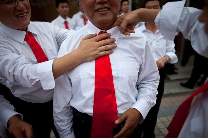 Communist Party 90th: Peopel adjust a man's tie, 90th anniversary of Communist Party