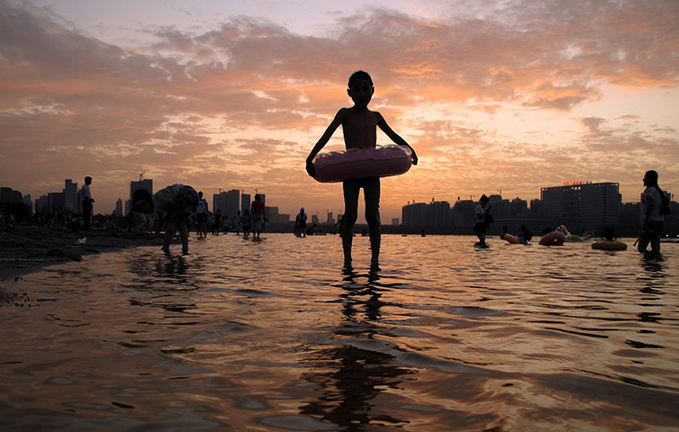 24 hours: Hefei, China: Residents cool off on a hot summer day in a river 