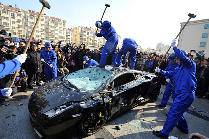Luxury cars in China: workers destroy a Lamborghini Gallardo