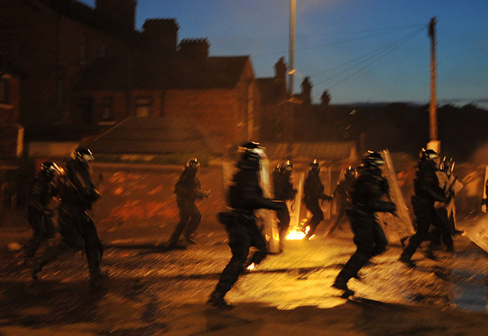 Ardoyne riots: Riot police with battons run towards a crowd of Nationalist youths