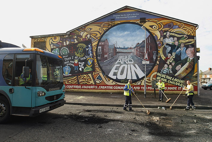 Ardoyne riots: Workers sweep debris and rubbish from a street 