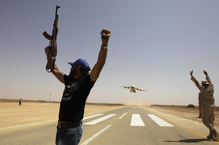 24 hours in pictures: Rebels wave as an Air Libya aircraft takes off from Rhebat air strip