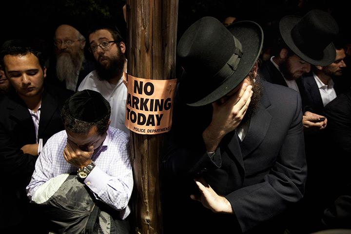 24 hours in pictures: Men weep while listening to the funeral in Brooklyn