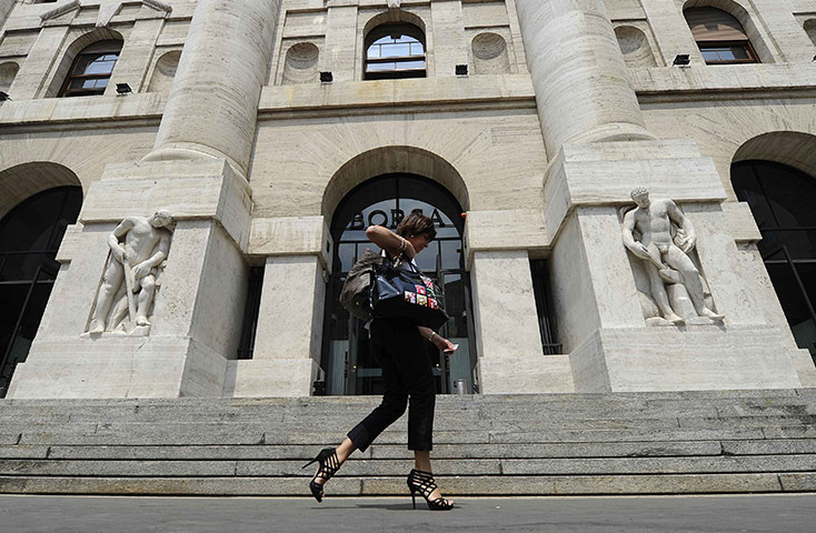 Week in Business: A woman walks past the Milan Stock Exchange