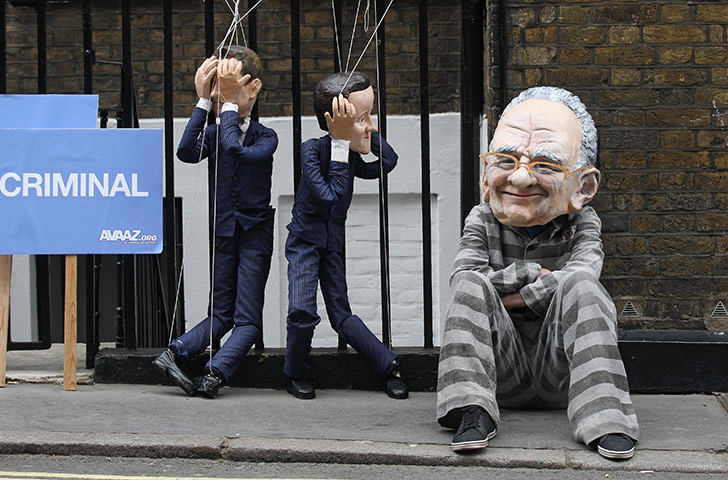 Week in Business: A protester wearing a Rupert Murdoch mask demonstrates