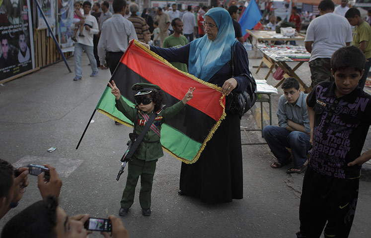 24 Hours: A girl dressed like Libyan leader Moammar Gadhafi poses in Benghazi