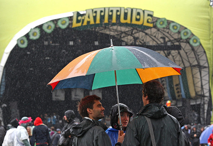 Latitude 2011: Festival goers shelter from the rain during the Latitude festival, Saturday