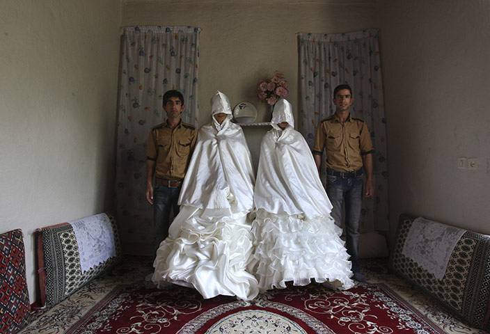 24 hours: Ghalehsar, Iran: Iranian grooms pose for photographs with their brides