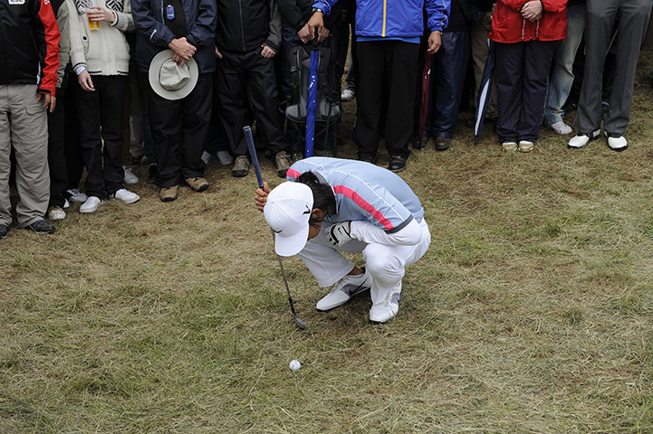 Open day 4: Anthony Kim closely examines his ball in the rough by the 6th green