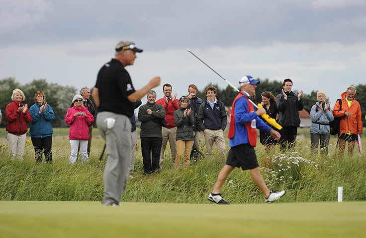 Open day 4: Fans outside the course by the 14th hole applaud Darren Clarke