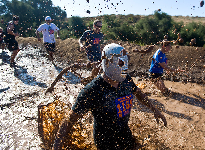 24 hours in pictures: Participant in luchador mask during the Irvine Lake Mud Run