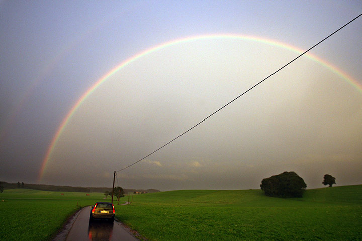 24 hours in pictures: A car drives under a rainbow  