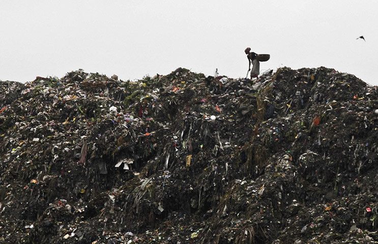 24 hours in pictures:  A woman scavenges in a rubbish dump in Kolkata