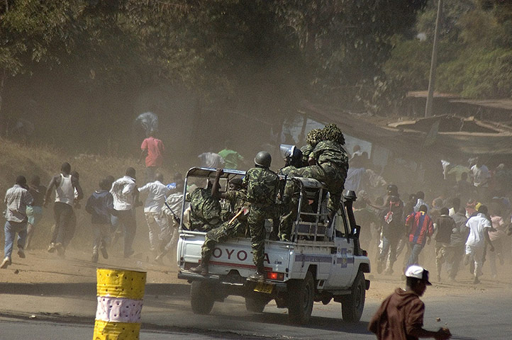 Malawi protests: Malawi Police chase a vehicle after anti government protests in Lilongwe