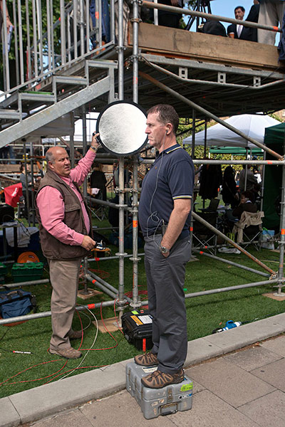 College Green media: A tv technician helps set-up for his tv news presenter 