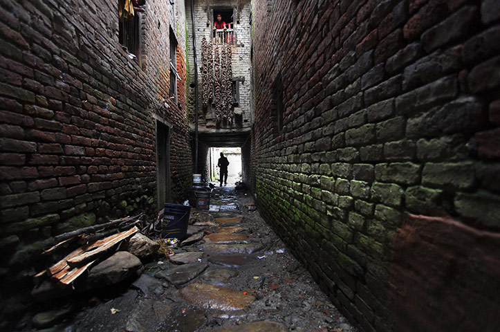 24 hours: Khokana, Nepal: A man returns home after performing morning chores