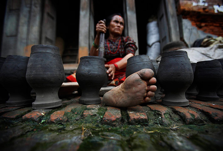 24 hours in pictures: A woman gives the finishing touches to a clay pot in Nepal