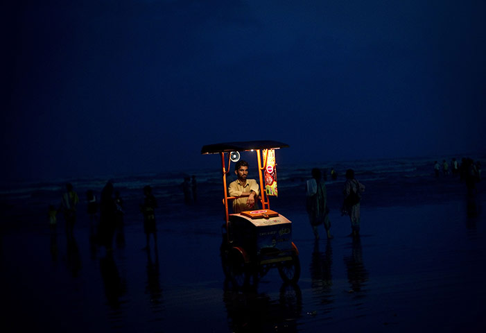 24 hours in pictures: A Pakistani ice cream vendor waits for clients at Sea View beach, Karachi,