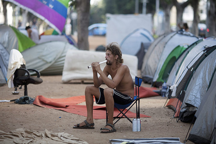 Tent City: An Israeli man plays on a flute amid tents