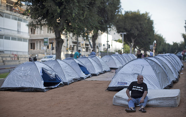 Tent City: A man rests in front of the makeshift homes