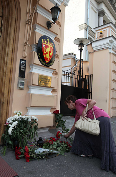 Norway Terror: A woman lays down flowers at the entrance of Norway's embassy in Moscow