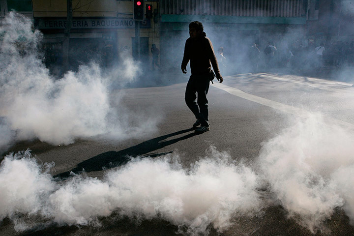 24 Hours: A student walks through tear gas during a rally in Santiago