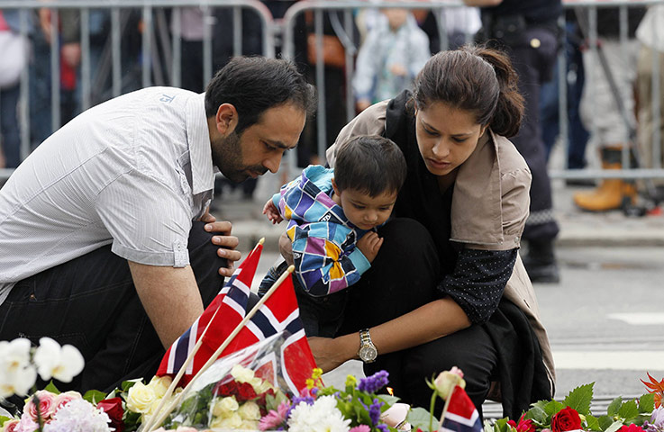 Norway aftermath: A family lights candles in Oslo 