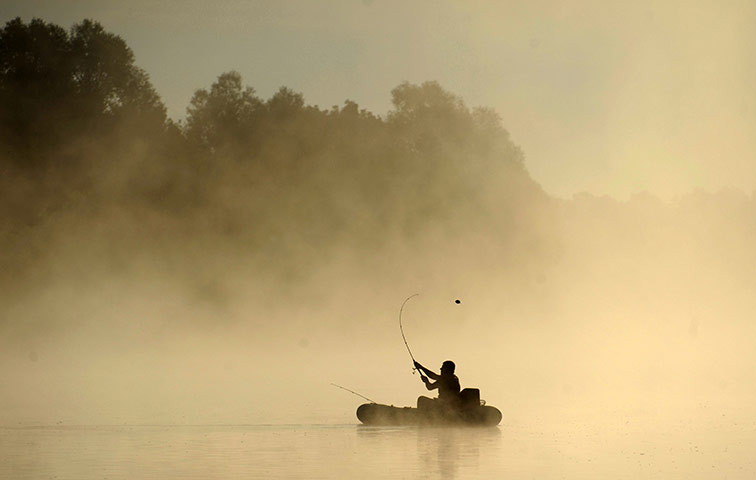 24 hours: A man fishes at sunrise on the river Sozh 